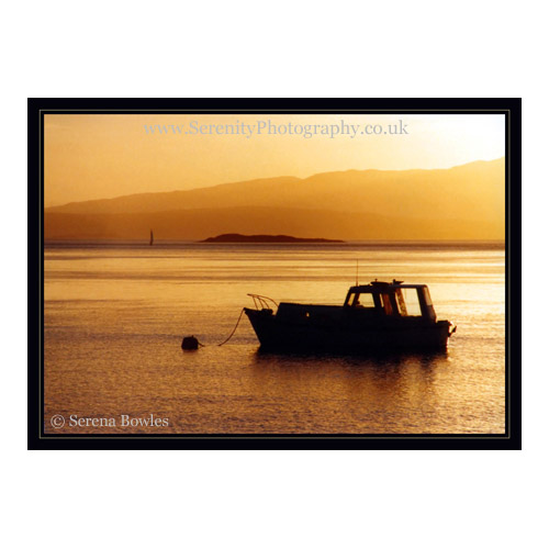Silhouetted boat against the golden glow of sunset. Oban, Scotland.